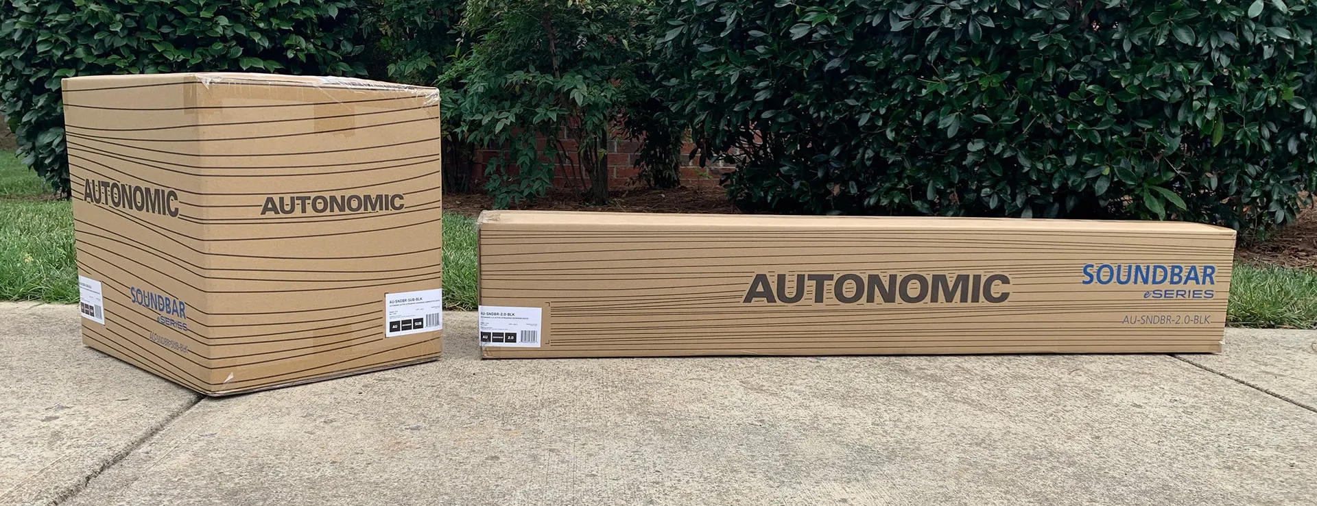 Autonomic soundbar packaging: two kraft boxes on a sidewalk