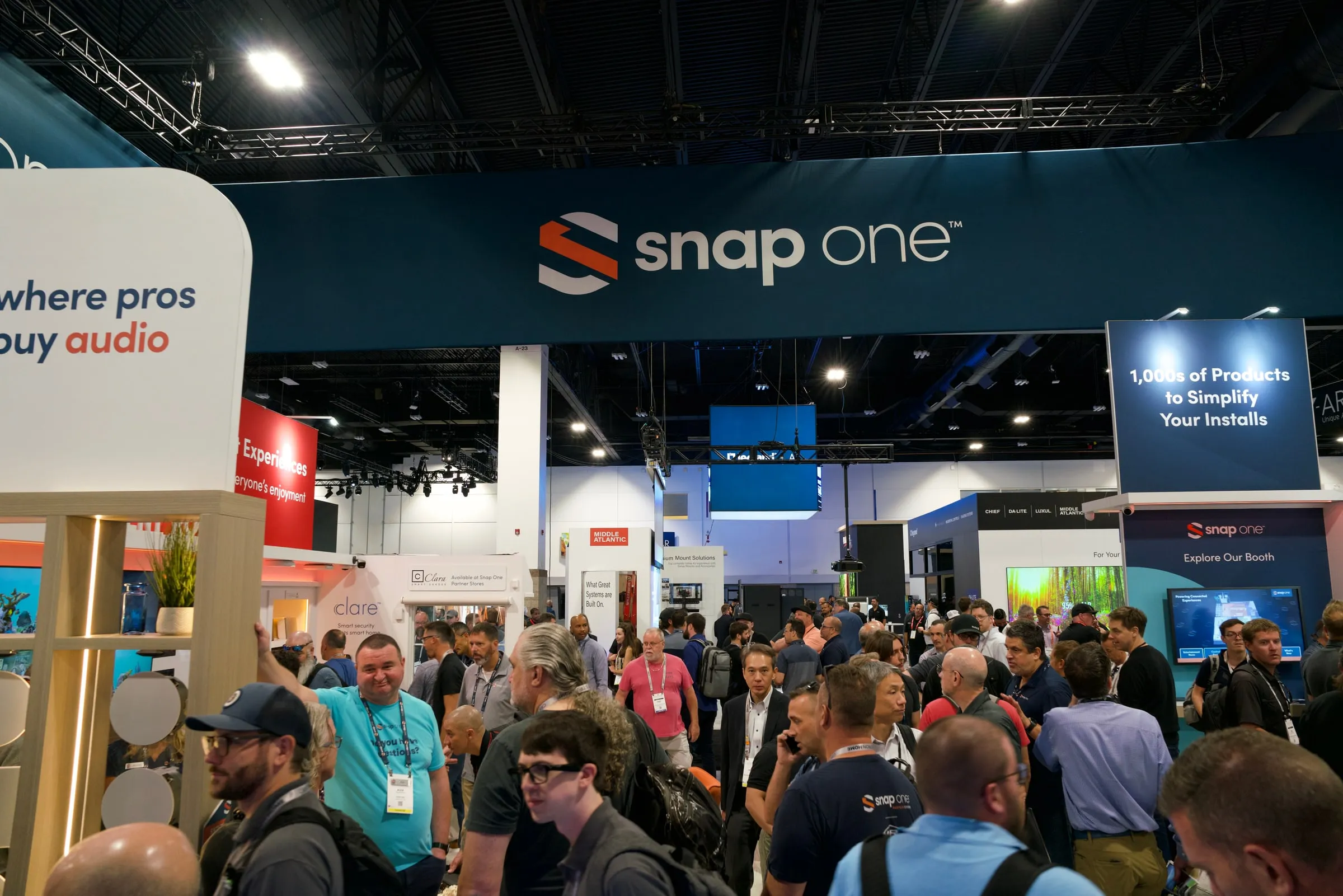 Wide view of crowds under the Snap One booth headers