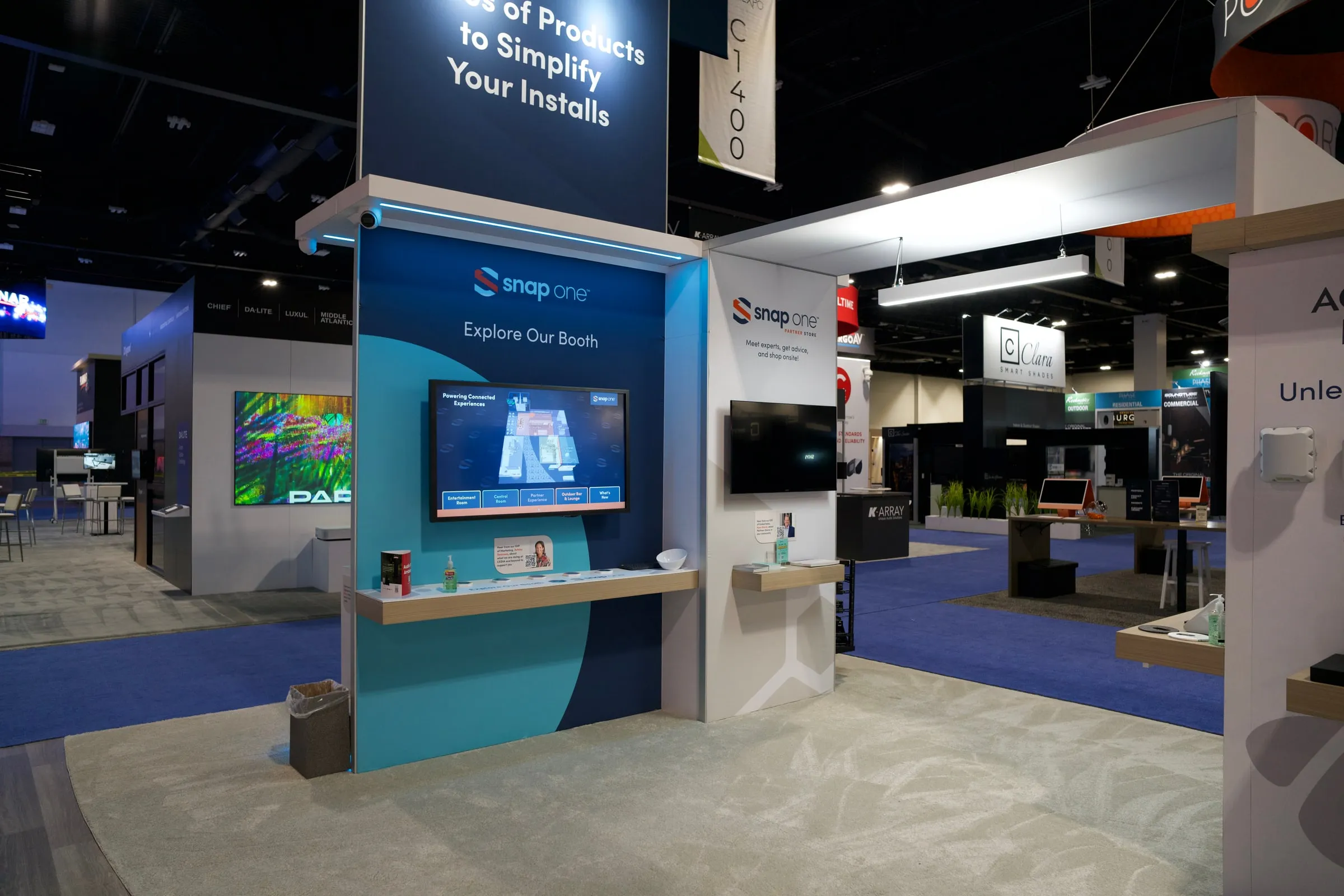 Booth area with a TV wall and "Simplify Your Installs" header before opening