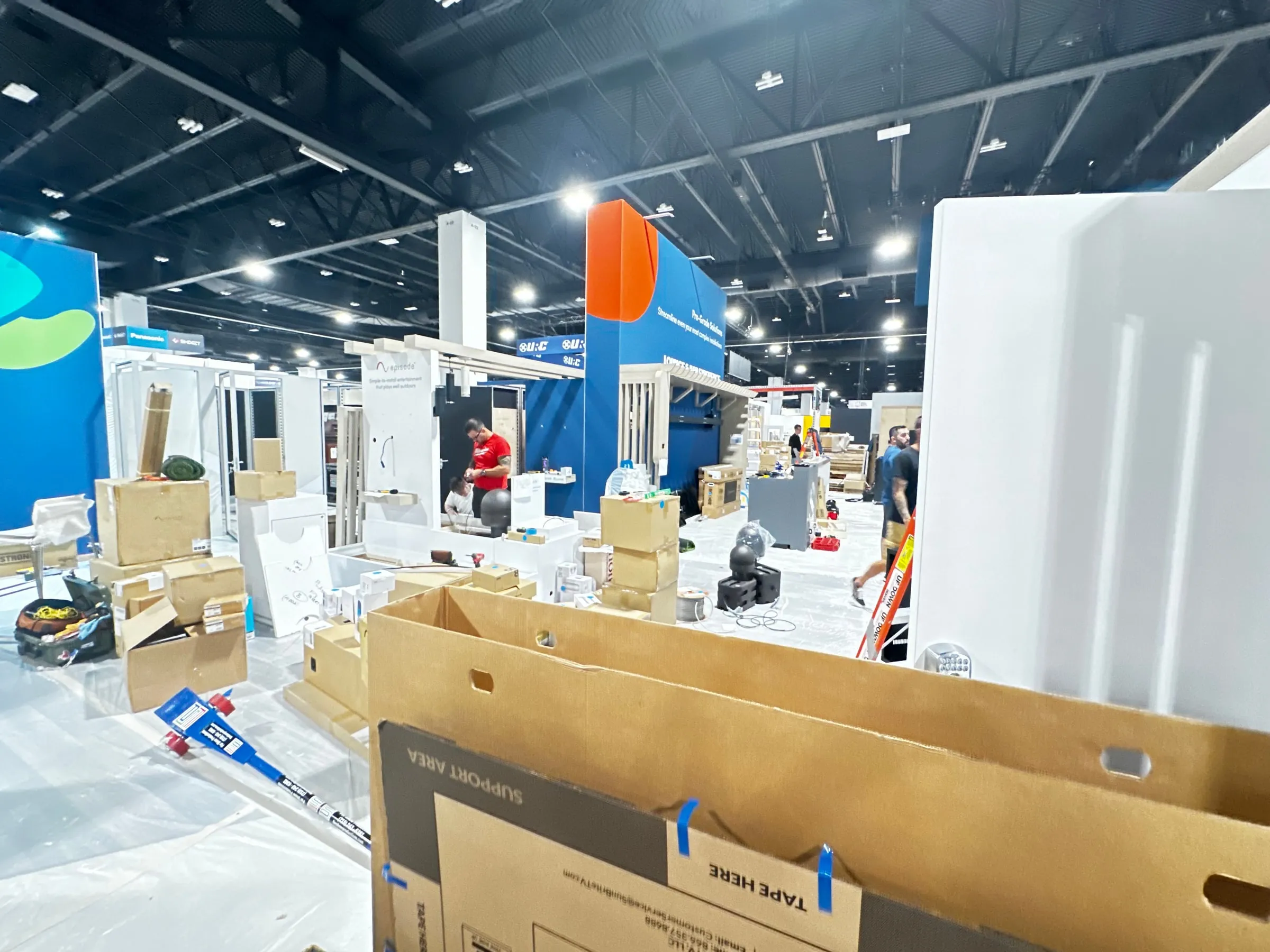 Booth setup in progress with boxes and tools on the show floor