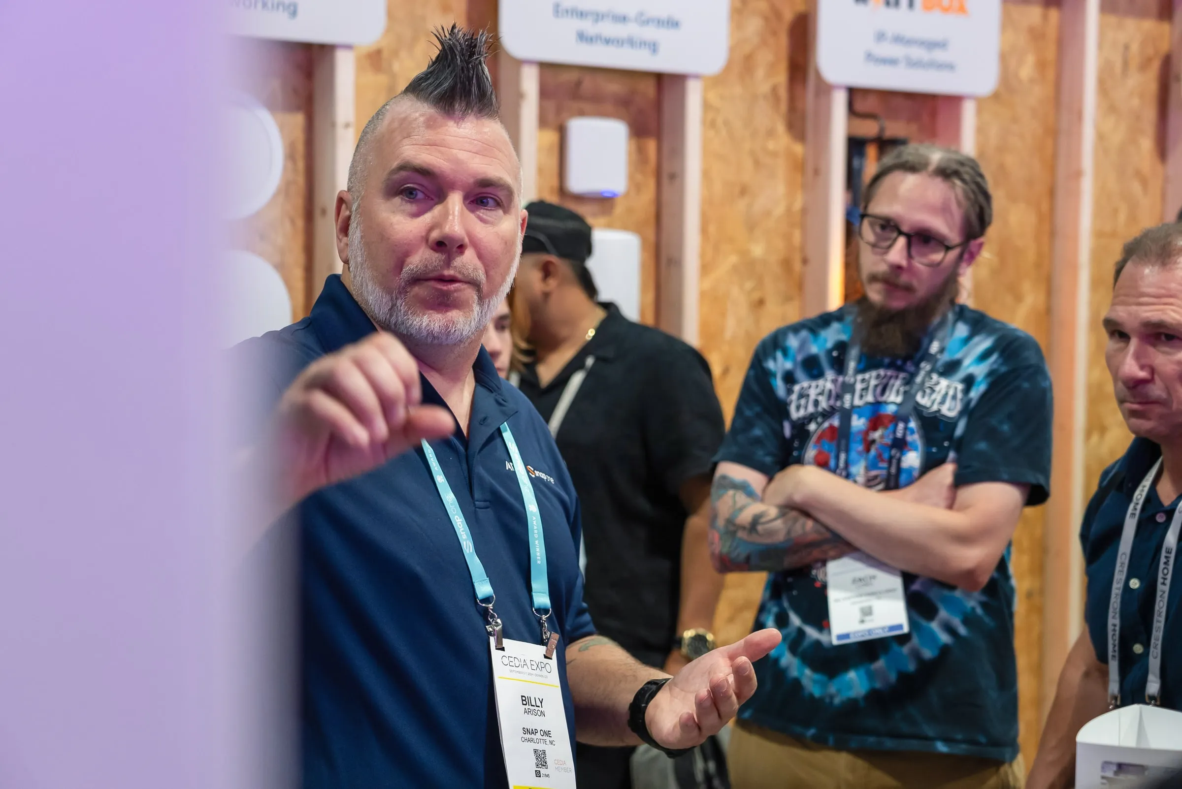 Visitors talking with a staff member in front of a product wall