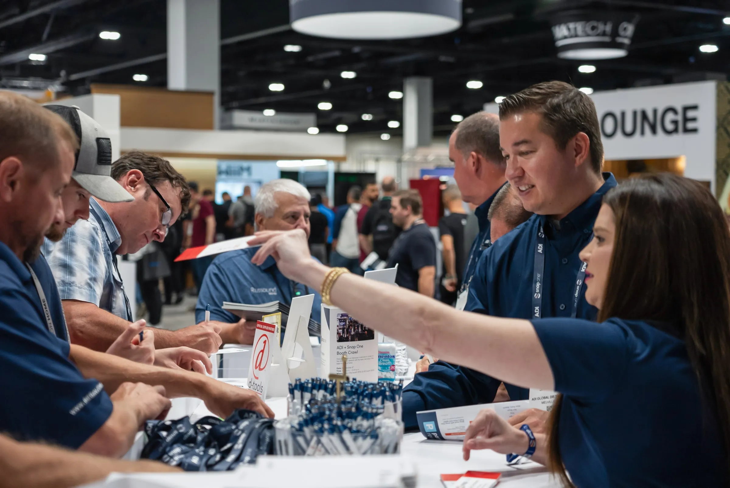 Staff member handing out giveaways to visitors at the booth counter
