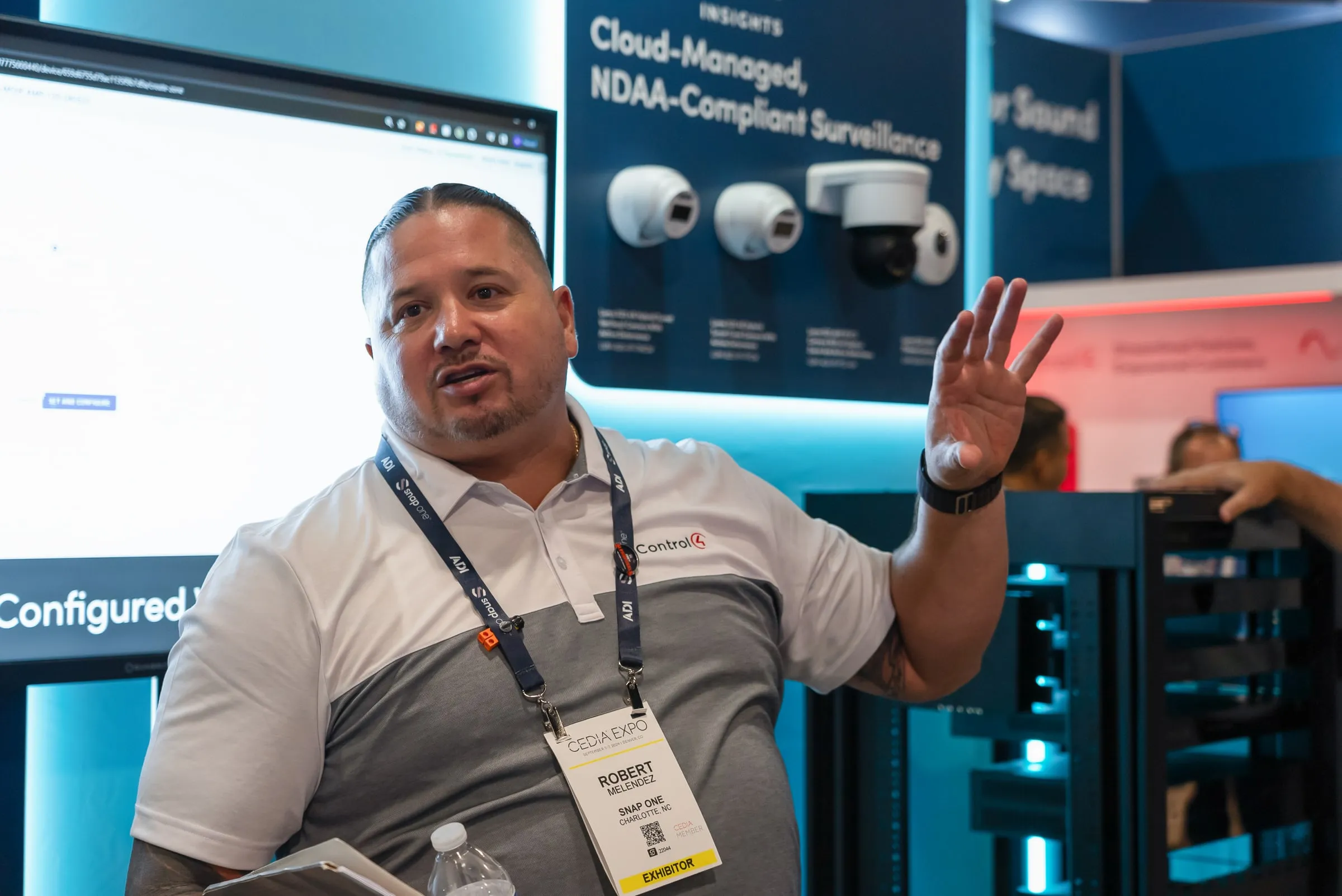 Staff member explaining cloud-managed, NDAA-compliant Luma surveillance cameras
