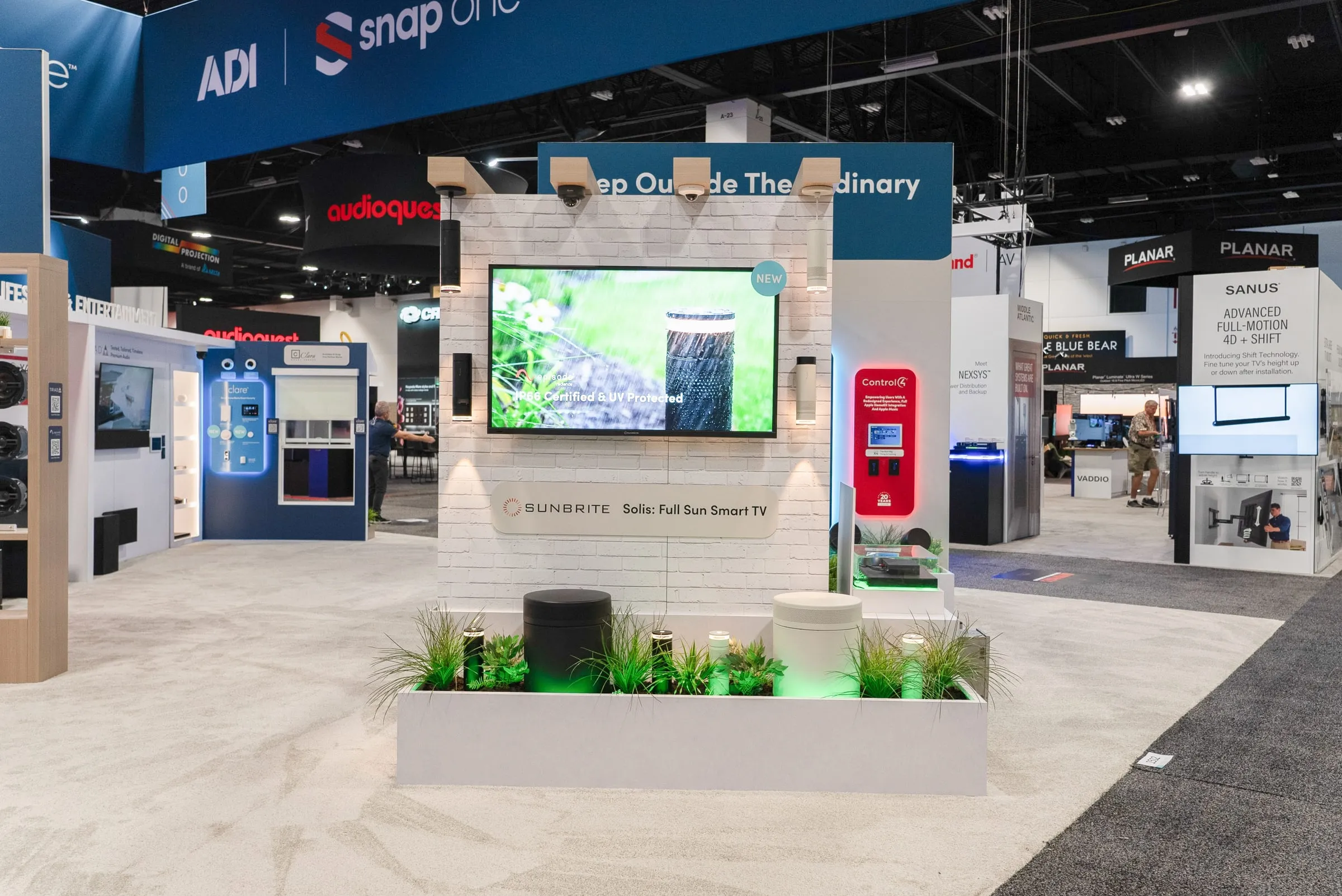 Outdoor living display with a large TV over a planter