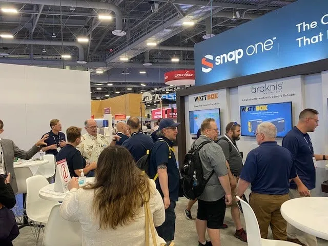 Crowd of visitors in the booth under the Snap One header