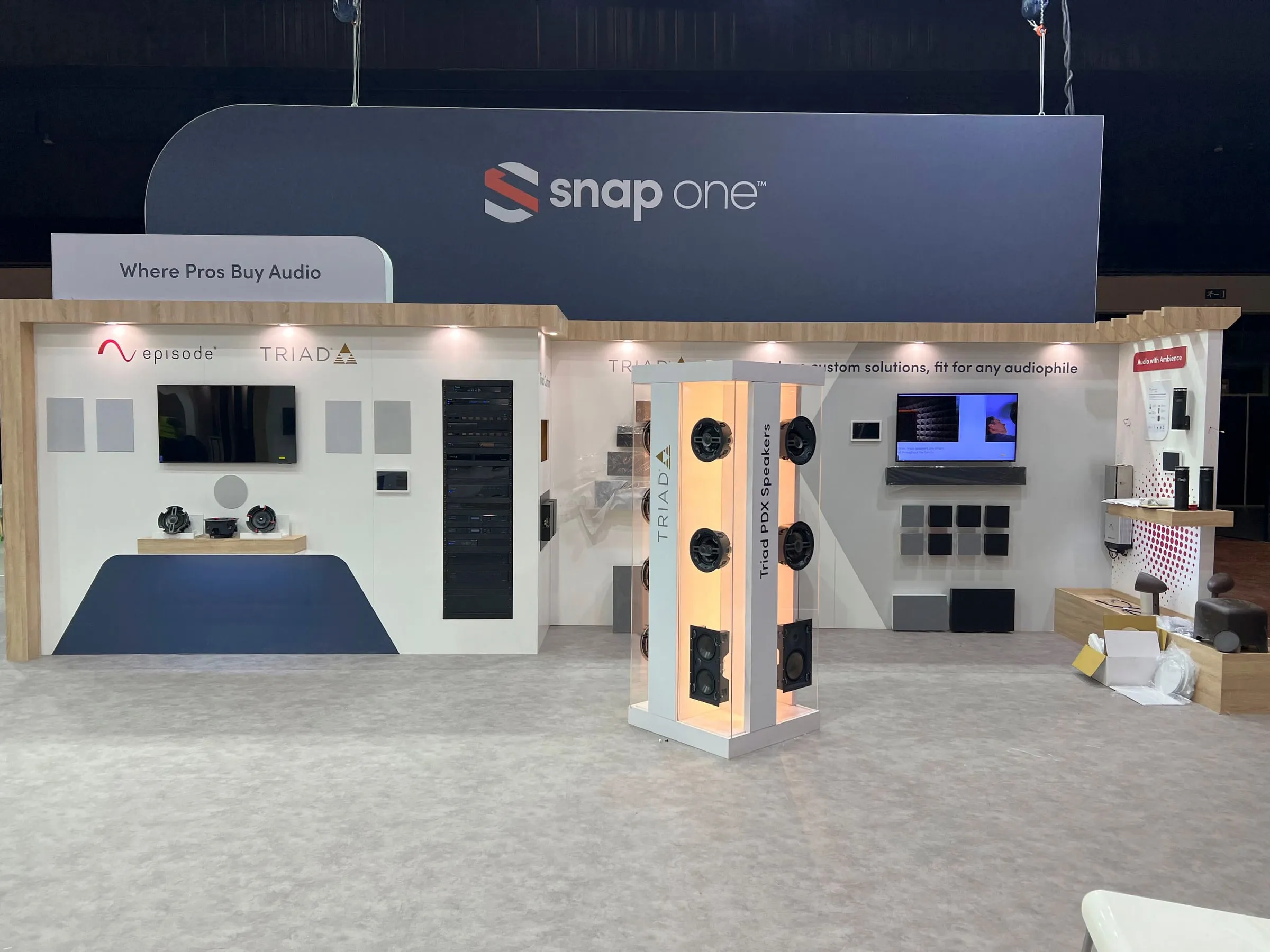 "Where Pros Buy Audio" wall with a lit speaker tower