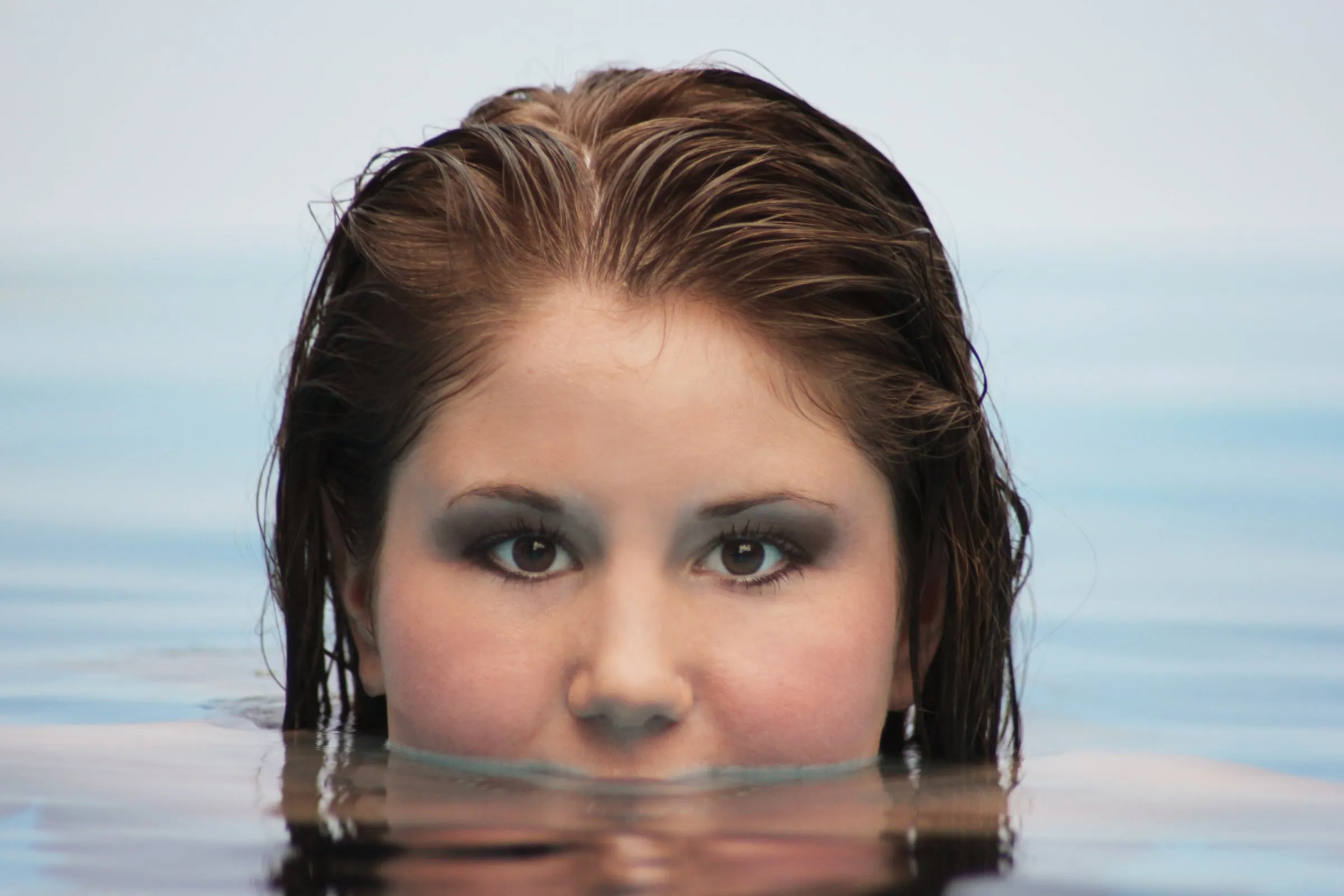 Close portrait of the model at the water line of the pool
