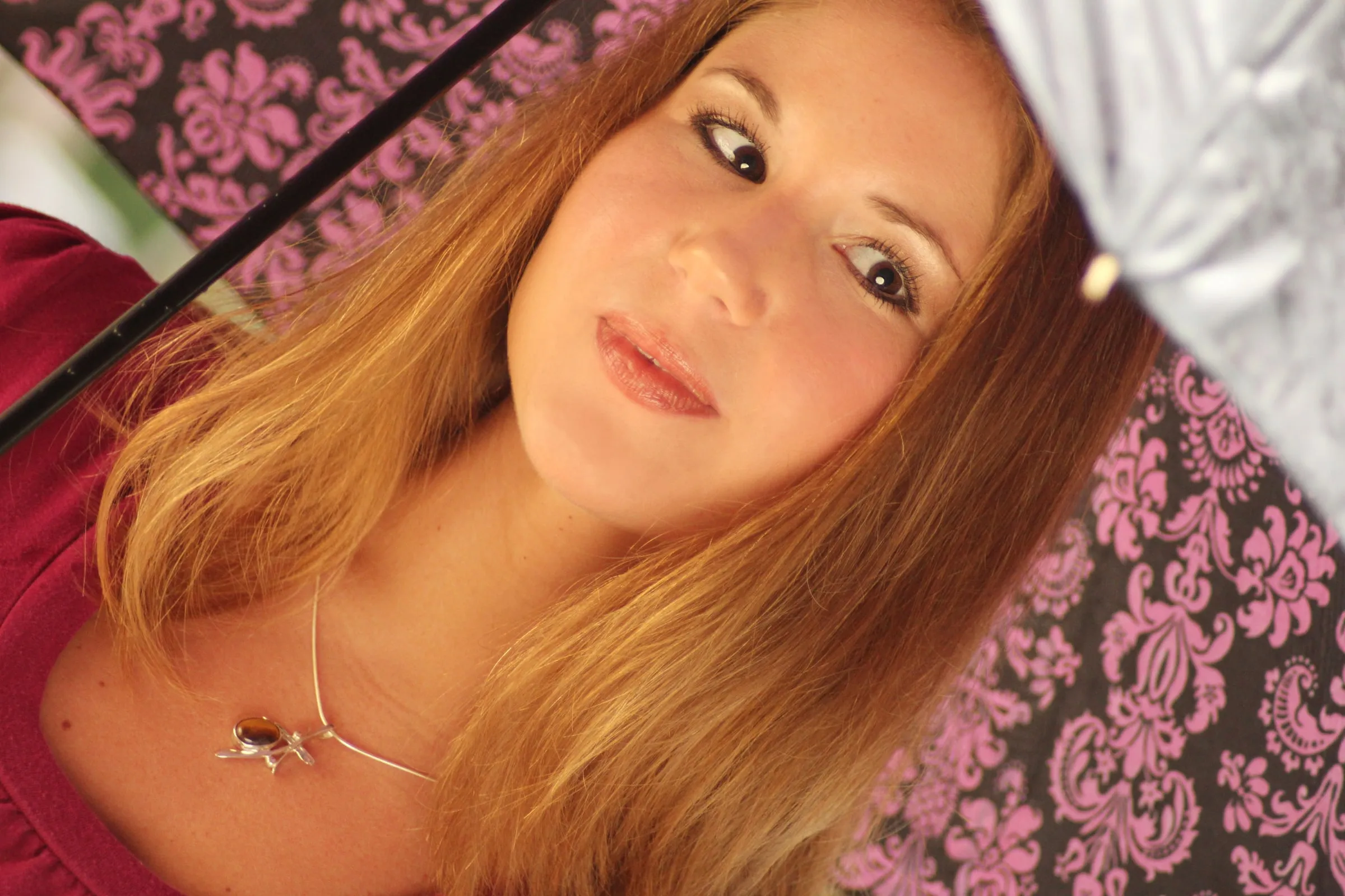 Tilted close-up of the model under the umbrella, necklace in focus