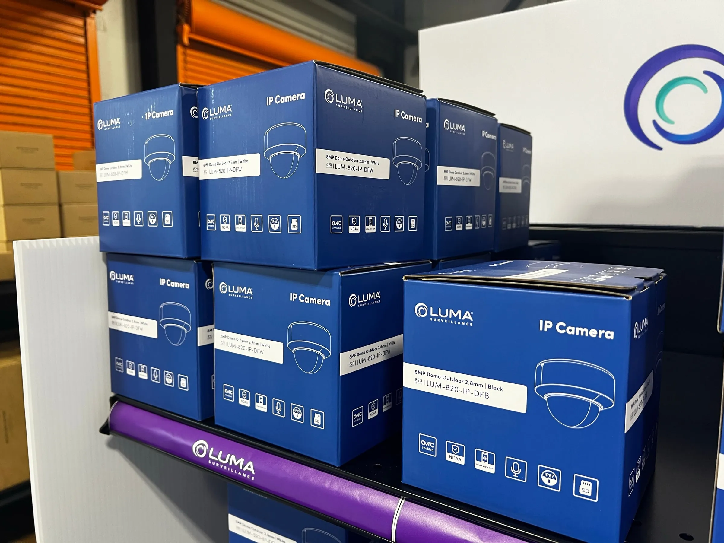 Close view of blue Luma IP camera boxes on a store shelf