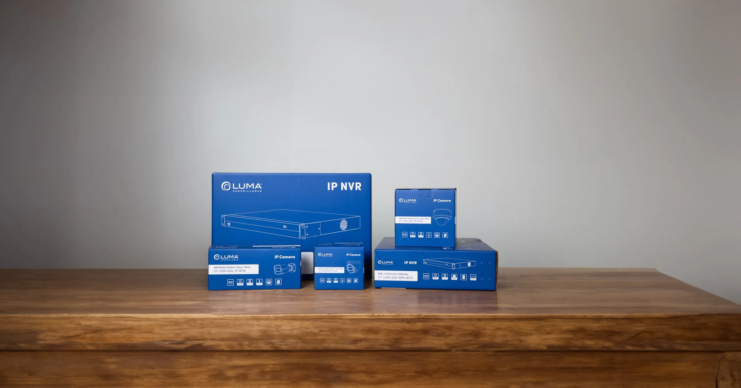 Row of blue Luma boxes in several sizes on a wooden shelf