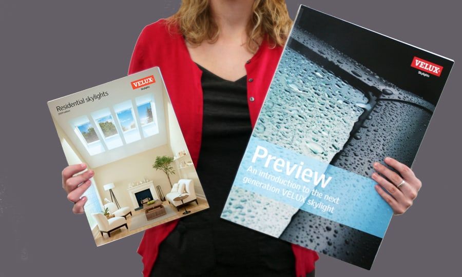 A person holding two VELUX brochures: Residential Skylights and Preview, an introduction to the next-generation VELUX skylight